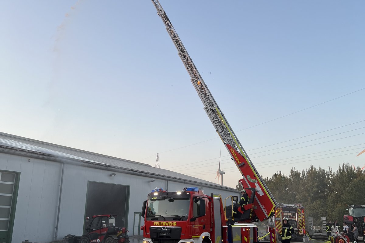 Ein Leiterfahrzeug der Feuerwehr mit ausgefahrener Leiter bei einer Übung