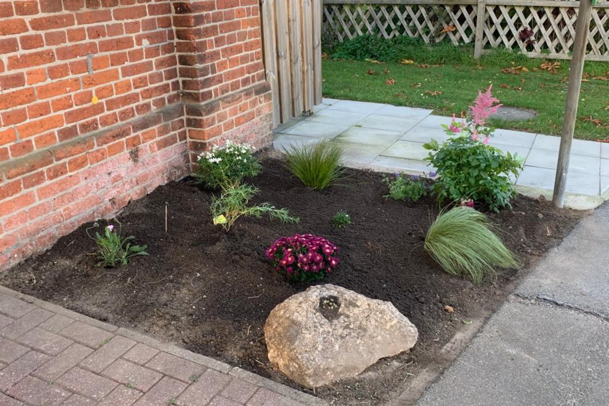 Frontansicht des Gemeinschaftshauses mit neuen Blumenpflanzen