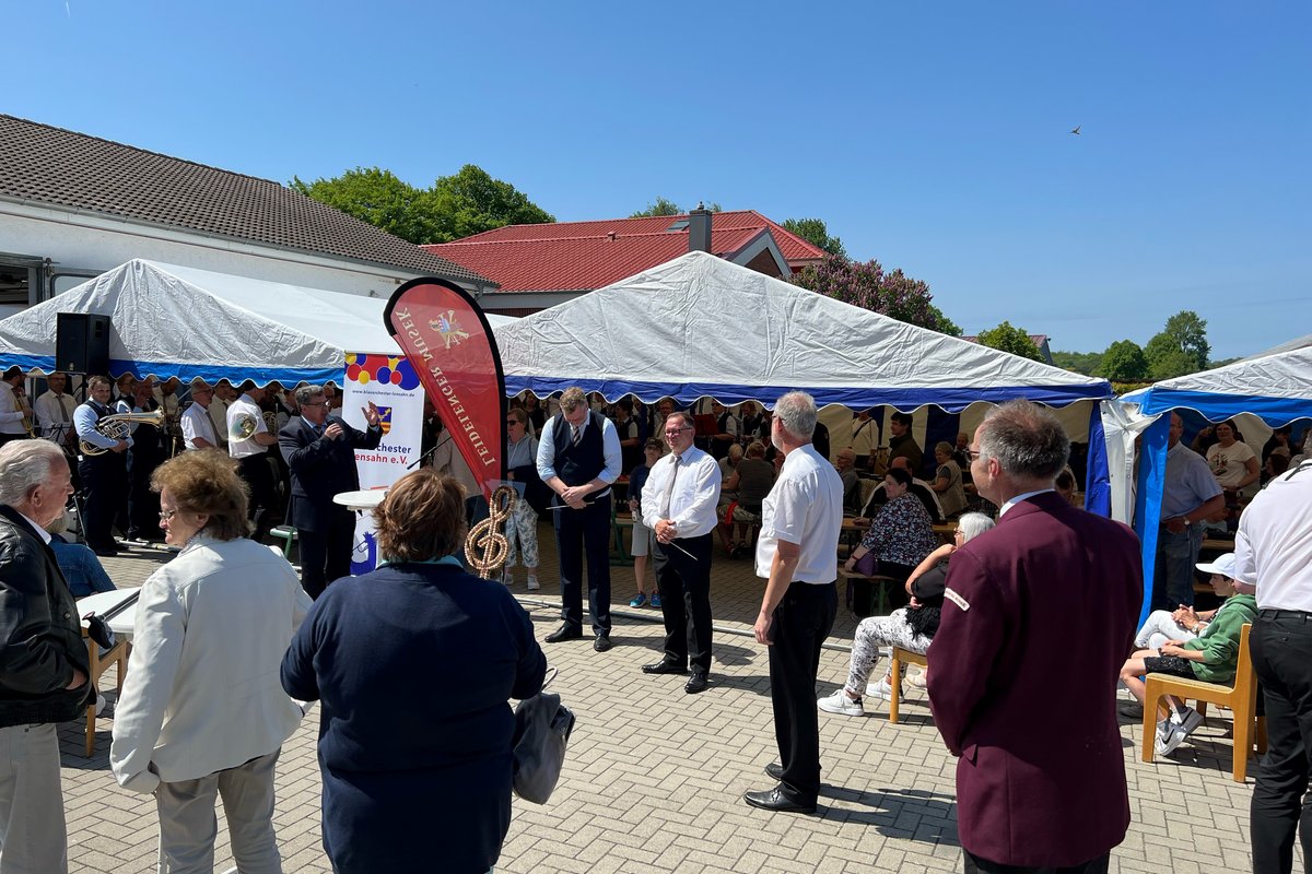 Besucher stehen auf dem Festplatz während der Eröffnungsrede