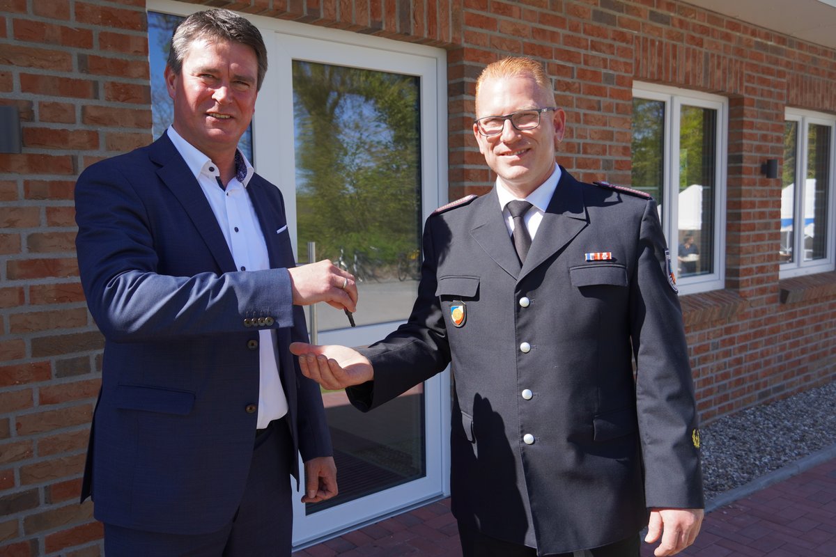 Bürgermeister Michael Robien übergibt des Schlüssel an Wehrführer Frank Paustian vor dem Enang zum neuen Feuerwehrhaus