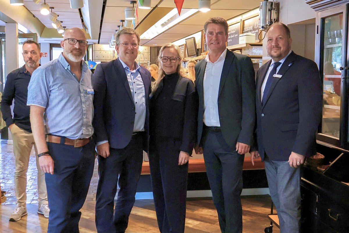 Bürgermeister Michael Robien, Landrat Timo Garz und 3 weitere Personen stehen am Tresen bei der Neueröffnung des Cafes