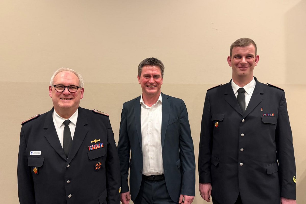 Bürgermeister Robien, Gemeindewehrführer Junge und stellvertrender Gemeindewehrführer Alexander Bendt posieren für ein Foto vor einer weissen Wand
